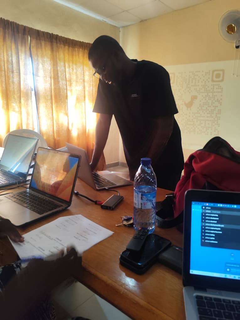 Rasheed leaning over a laptop while presenting SWEMLab to staff