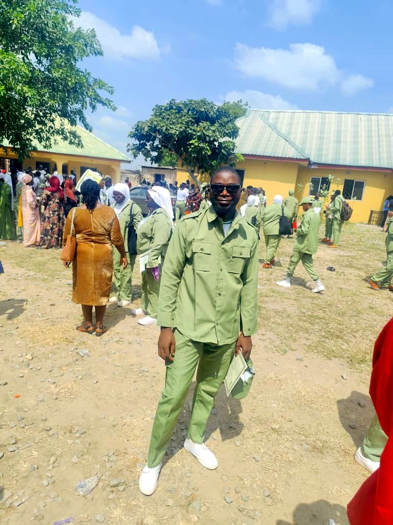 Rasheed Taiwo in NYSC khaki uniform holding his Certificate of National Service on Passing-Out Parade day