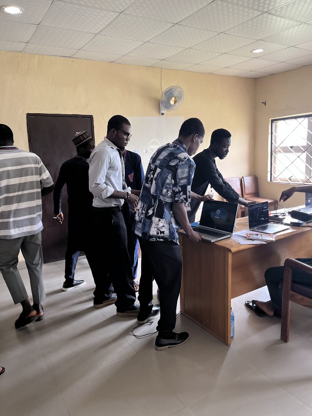 Lecturers and a student team gathered around a laptop during project presentations