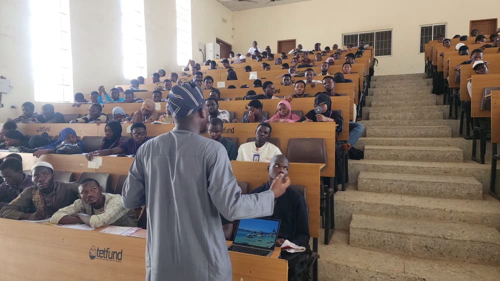 Rasheed addressing a full lecture hall of students